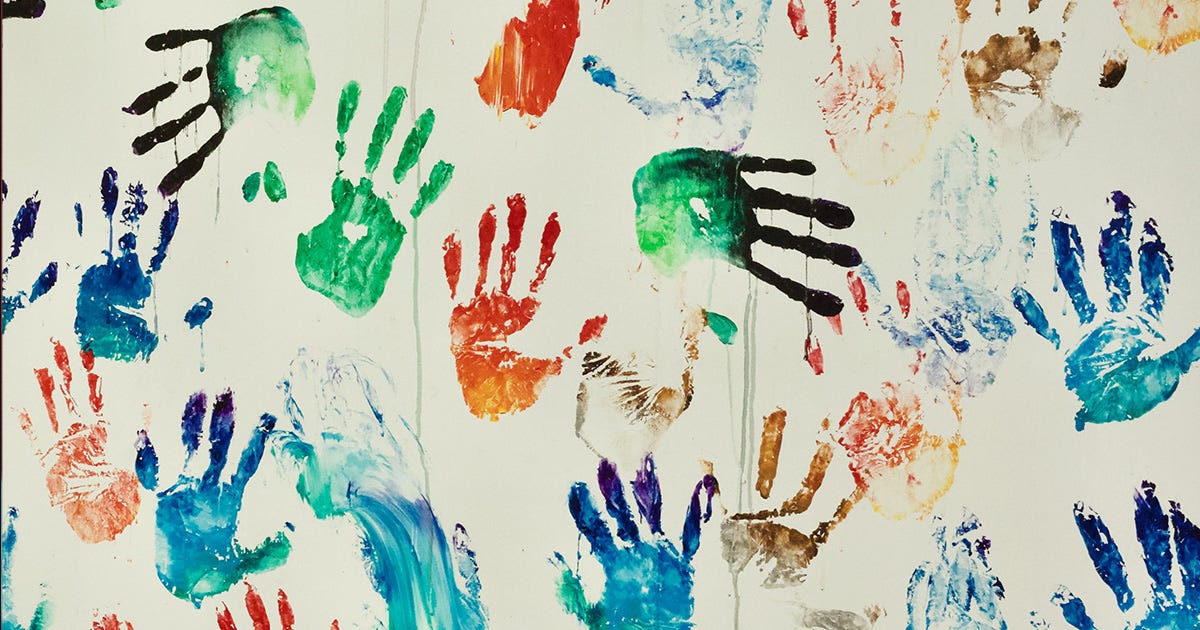 Bunte Abdrücke von Kinderhänden auf einer Wand.