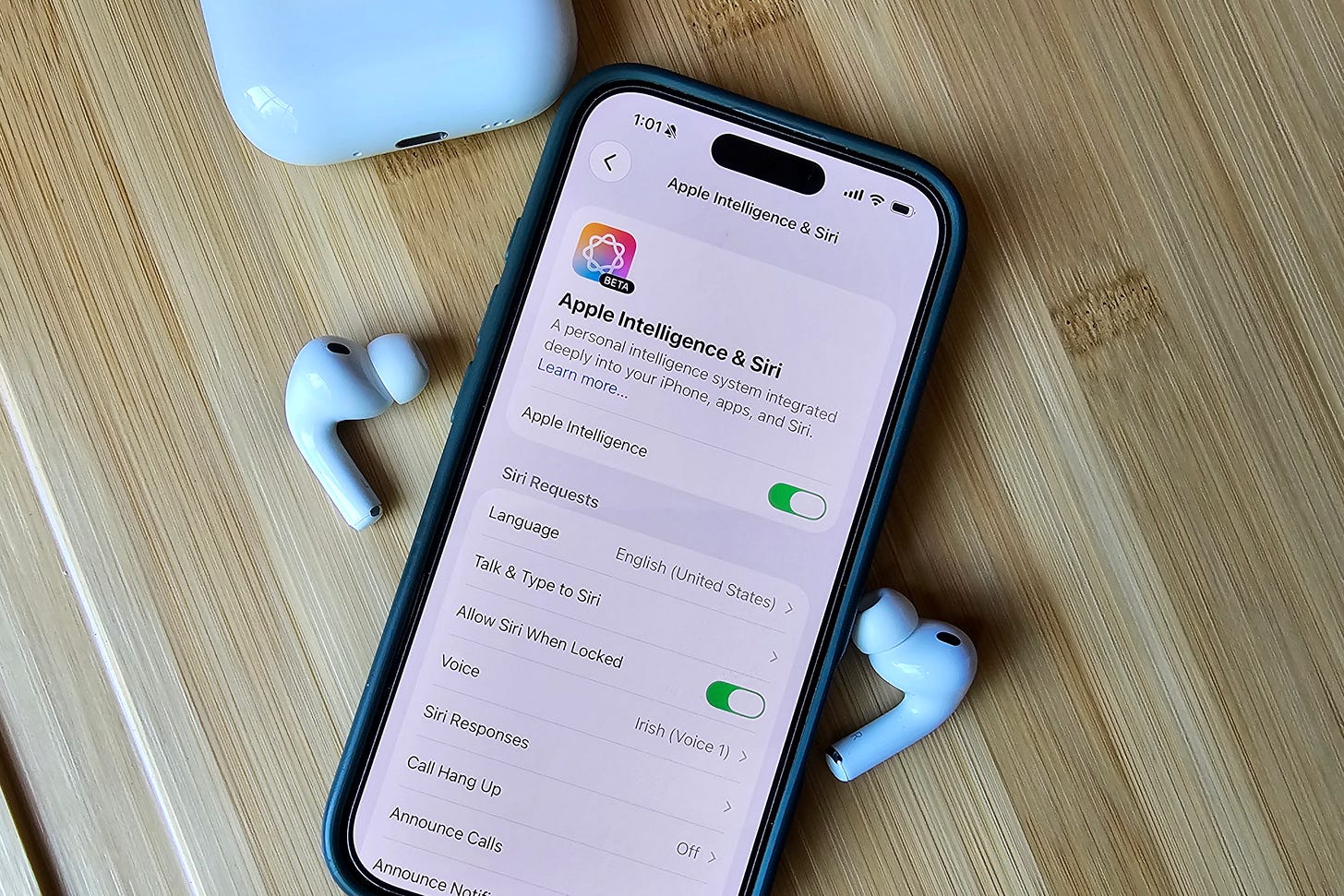 Apple AirPods Pro 3 sitting next to an iPhone 16 showing Apple Intelligence settings on the screen. Apple AirPods Pro 3 sitting next to an iPhone 16 showing Apple Intelligence settings on the screen.