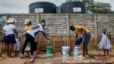 Residents fill containers with safe drinking water after a cholera outbreak in the Kuwadzana township in Zimbabwe's capital Harare