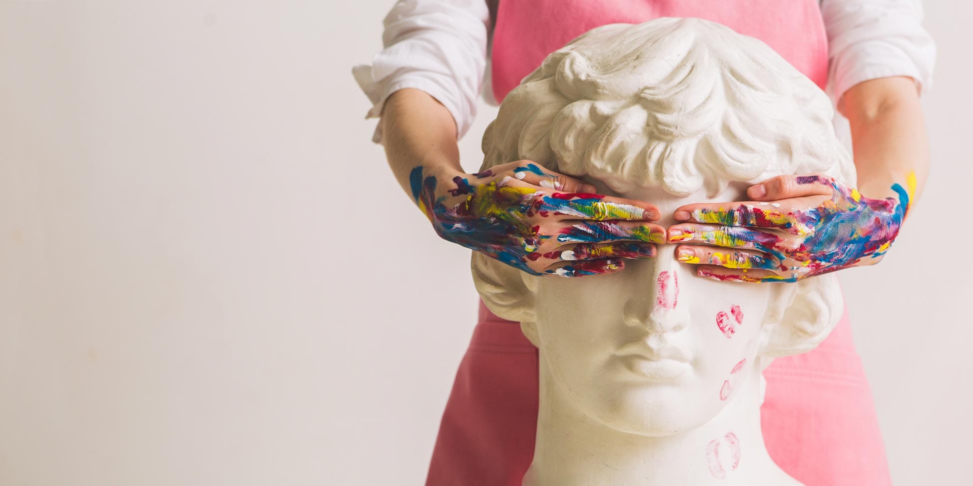 White sculpture covered by many-coloured hands representating creativity.