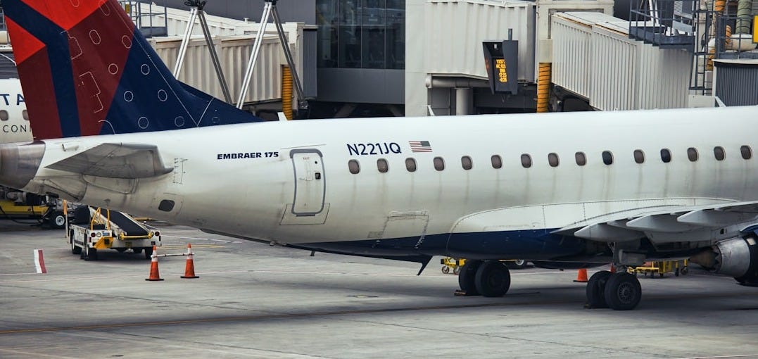 a man standing in front of an airplane at an airport a man standing in front of an airplane at an airport
