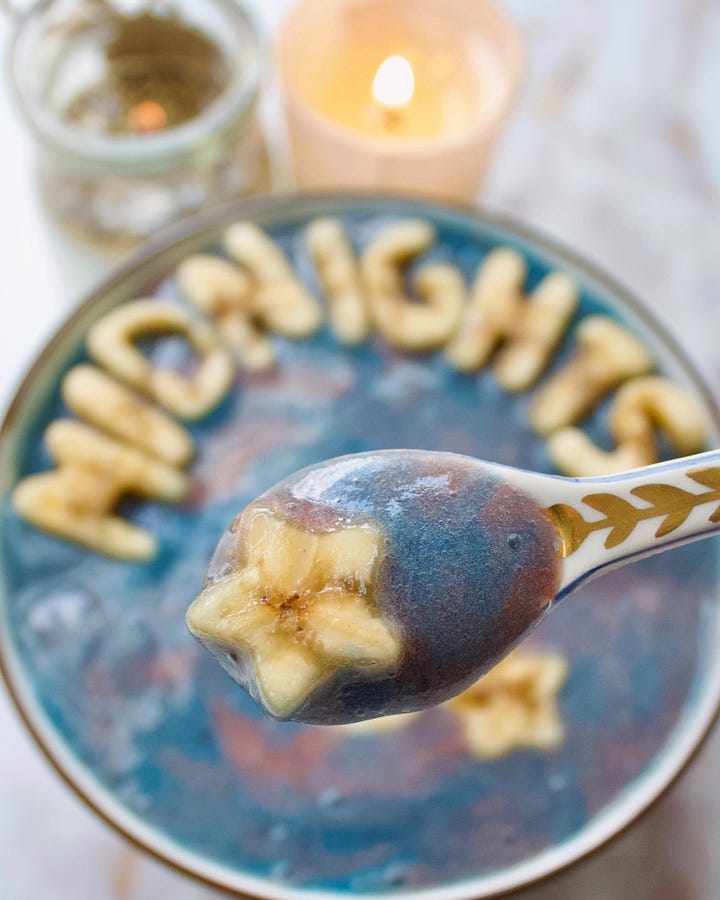 two photos of a Midnights themed smoothie bowl, of blue and red swirls and banana letters on top.