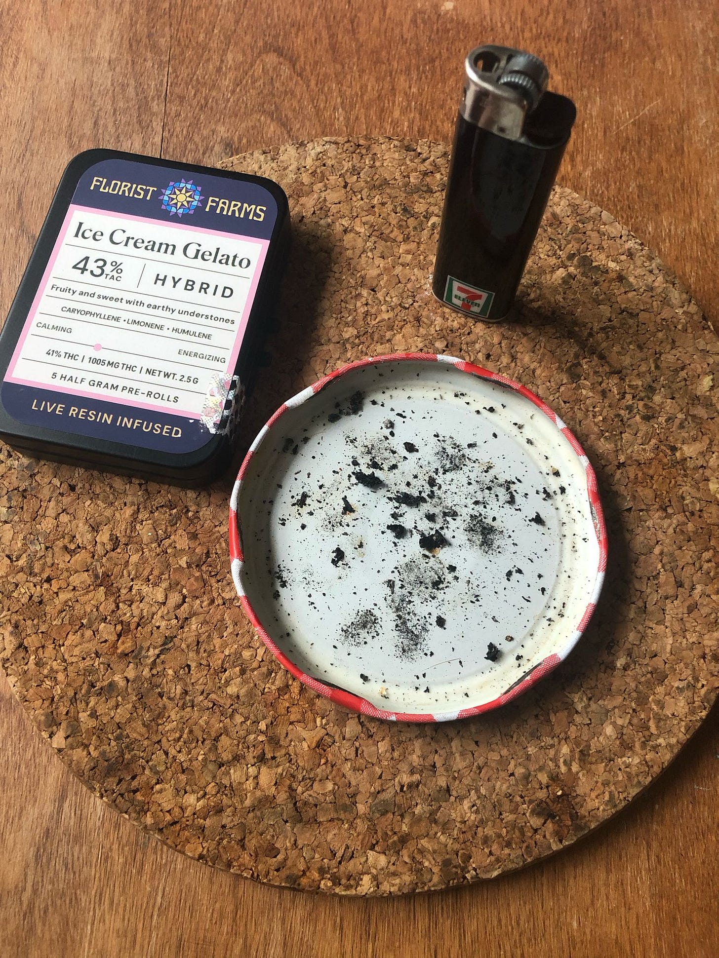 a lighter, a package of five pre-rolls, and a Bonne Maman jar lid being used as an ashtray