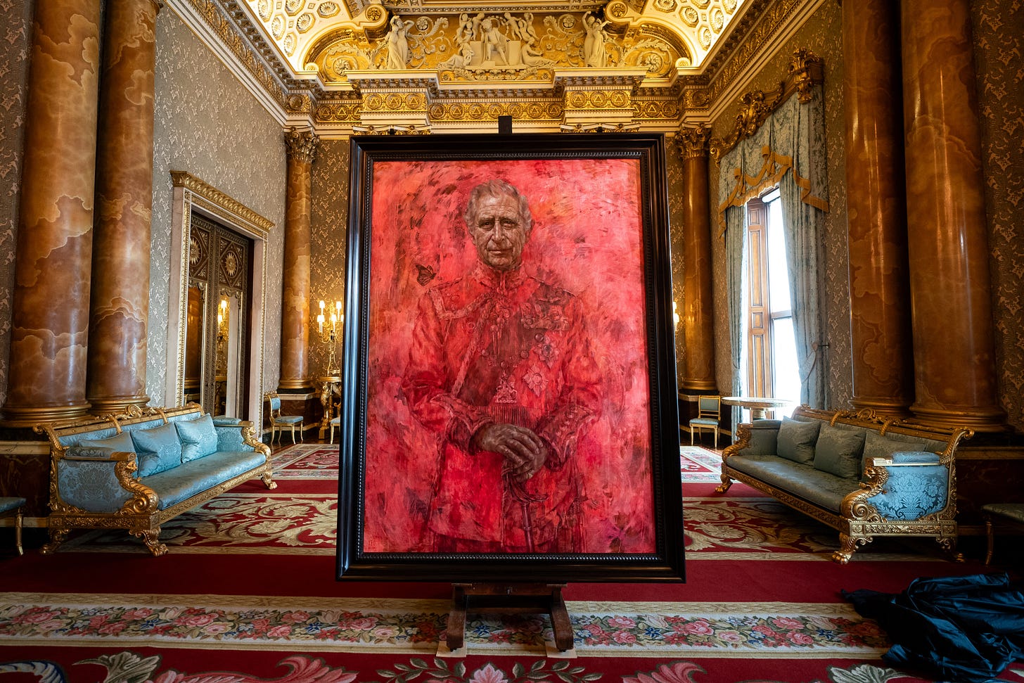 Red portrait of King Charles at Buckingham Palace