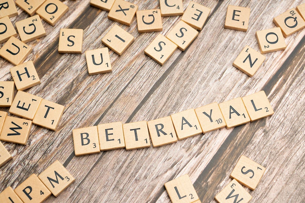 betrayal spelled out in scrabble pieces on wooden surface — unsplash