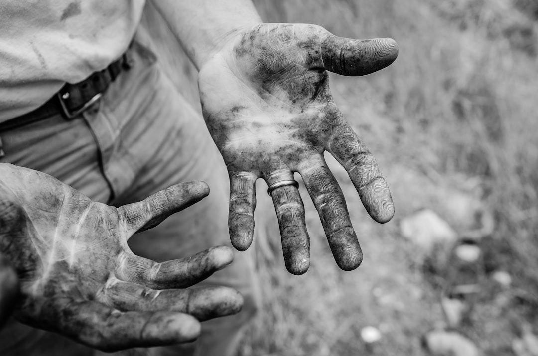 A man with his hands covered with mud
