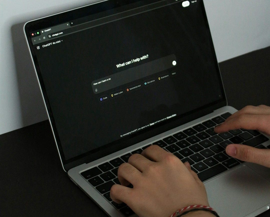 A person typing on a laptop on a table