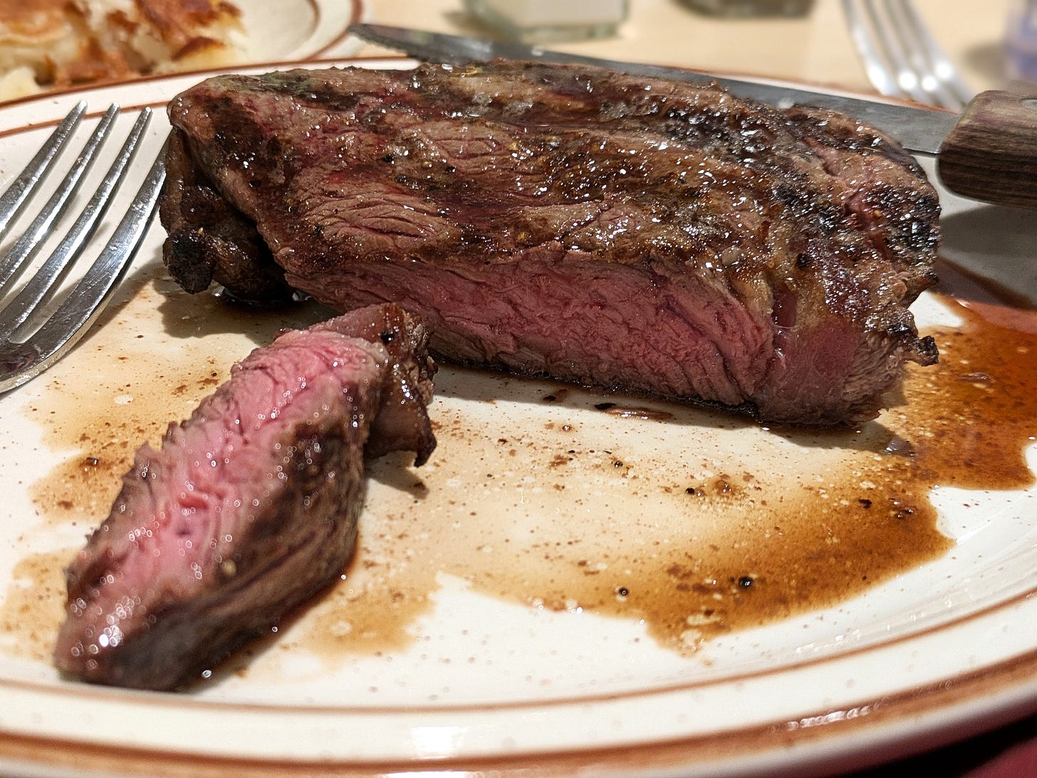 Close up photo of a sirloin with a piece cut off to show the pink inside.
