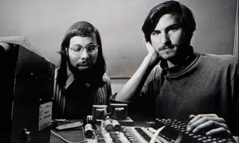 Steve Jobs and Steve Wozniak working on an early Apple computer in a garage