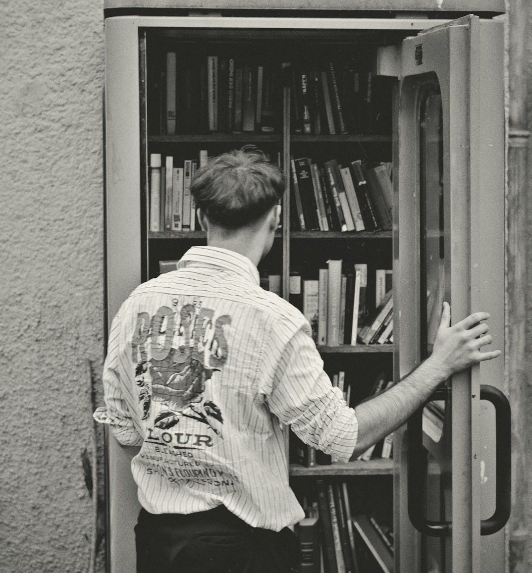 A man standing in front of a book shelf