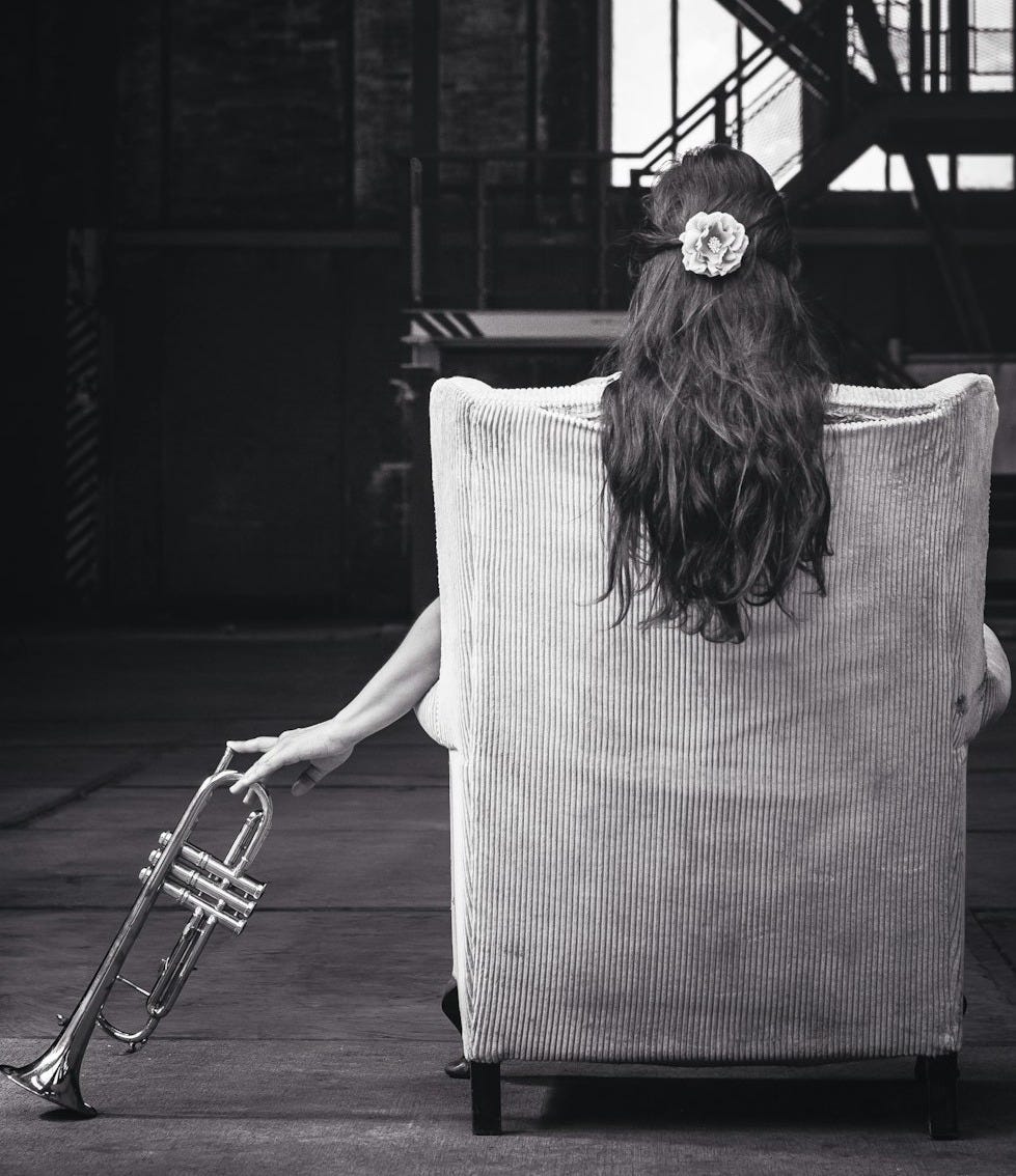 woman sitting on chair holding trumpet