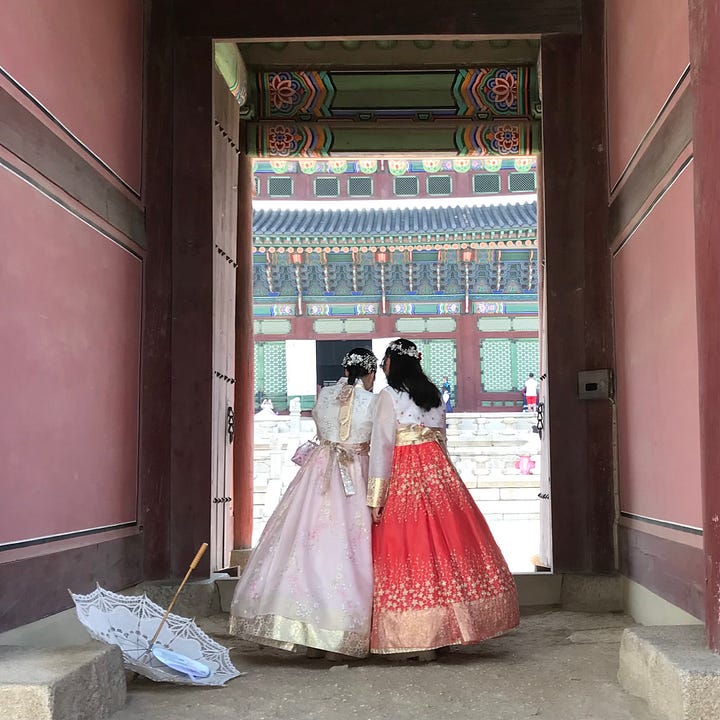 Visitors to the Gyeongbokgung palace in Seoul dressed in traditional Hanboks