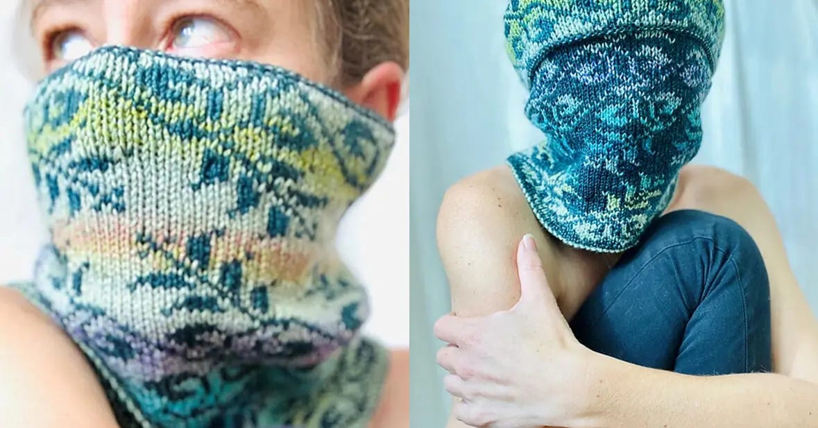 A woman is wearing a double-knit cowl with colorwork knitted leaf designs, knit in various shades of blue and multi-colors.