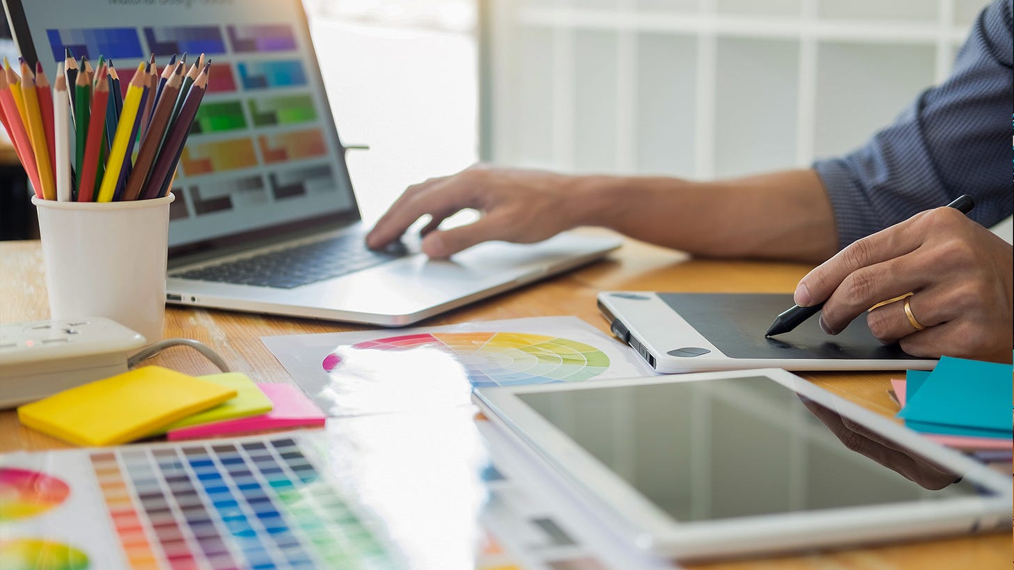 Designer working beside color swatches, markers, and a tablet during brand design