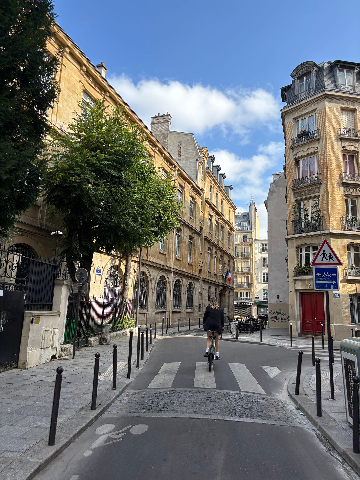 Empty street in Saint-Germain-des-Prés with a lone cyclist, August in Paris Empty street in Saint-Germain-des-Prés with a lone cyclist, August in Paris