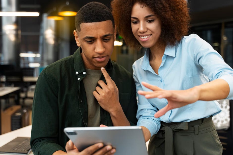 Deux individus noirs regardant un iPad. Deux individus noirs regardant un iPad.