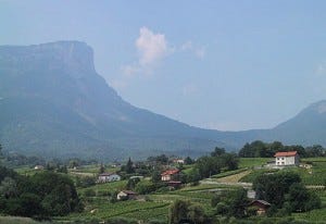 The towering cliffs of Mont Granier loom behind Labbés Abymes vineyards. Photo from Skurnik Wines. The towering cliffs of Mont Granier loom behind Labbés Abymes vineyards. Photo from Skurnik Wines.