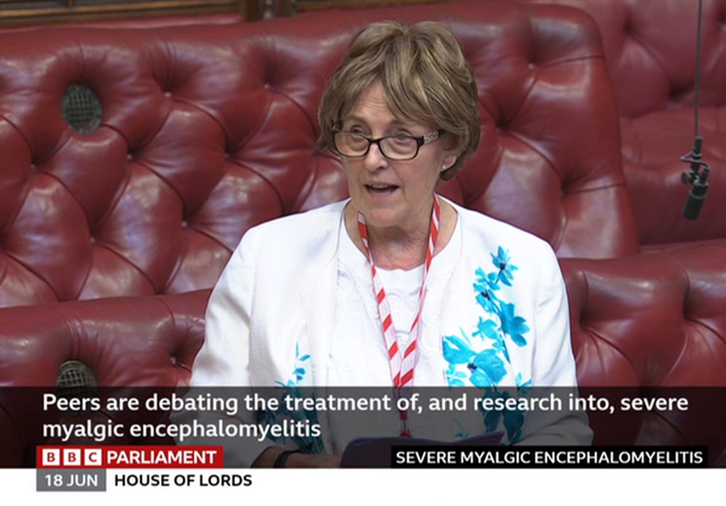 Screenshot from BBC Parliament, 18 June: Baroness Scott of Needham Market speaks in the House of Lords, seated on the red benches, wearing a white floral jacket and glasses. The on-screen caption reads "Peers are debating the treatment of, and research into, severe myalgic encephalomyelitis." Screenshot from BBC Parliament, 18 June: Baroness Scott of Needham Market speaks in the House of Lords, seated on the red benches, wearing a white floral jacket and glasses. The on-screen caption reads "Peers are debating the treatment of, and research into, severe myalgic encephalomyelitis."