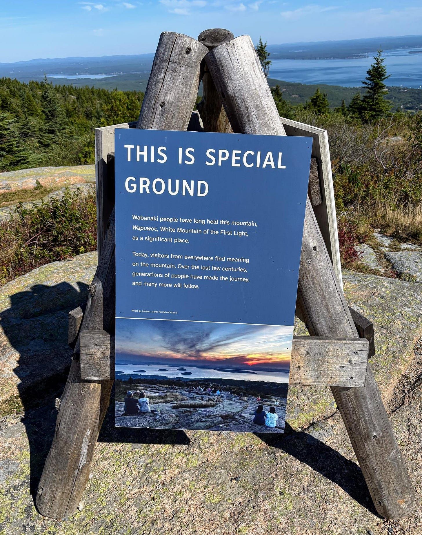 May be an image of 1 person and text that says 'THIS IS SPECIAL GROUND Wabanaki peaple have long held this mountain. Waolwoc Mountain the he Firs irst Light, as Stgrificant place. Teday, visttars Tram everywhere maurtain. ast cent enturles, generationso paople gwa made he Journey, ard nany many more will follow, mor nsemny รนะท์หนน'