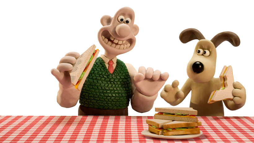 A claymated man and dog reach for a stack of sandwiches