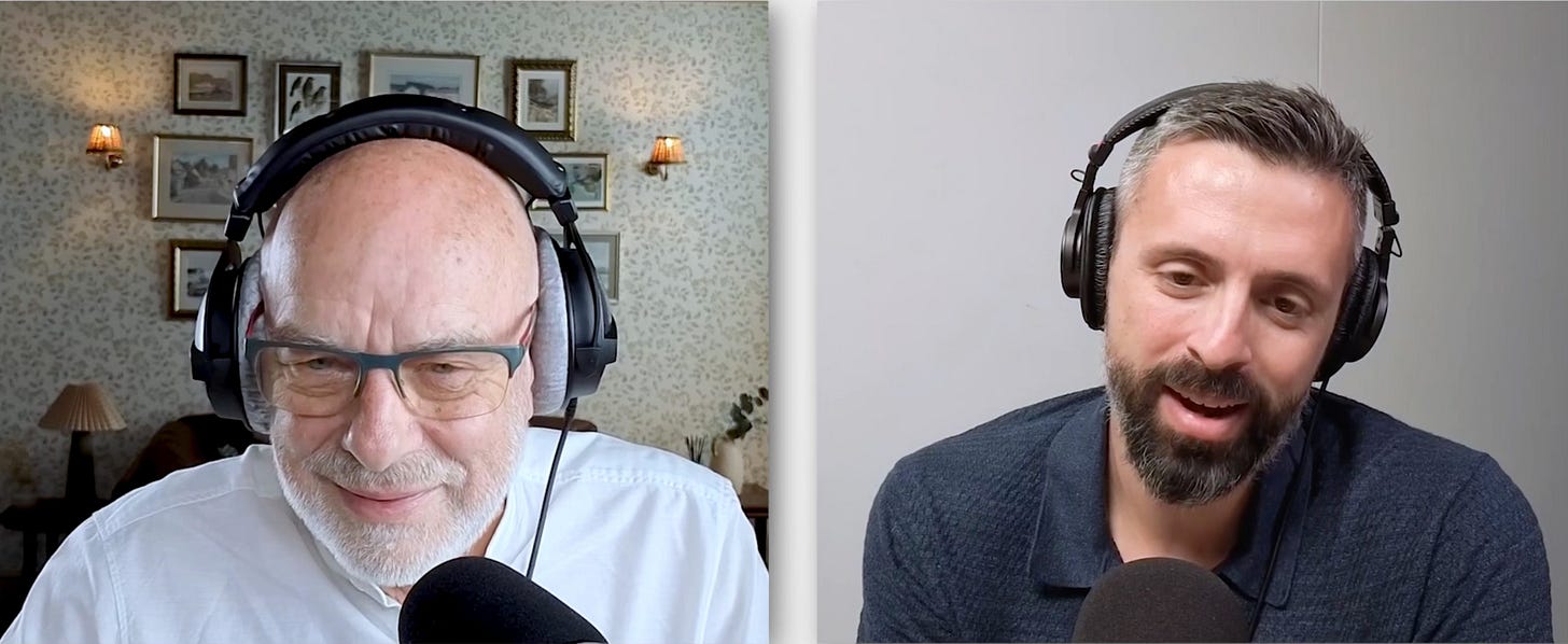 Screenshot van de video van het interview. Je ziet links Brian Eno met koptelefoon op in zijn huis, rechts Ezra Klein in zijn kantoor. Ze praten in de microfoon Screenshot van de video van het interview. Je ziet links Brian Eno met koptelefoon op in zijn huis, rechts Ezra Klein in zijn kantoor. Ze praten in de microfoon