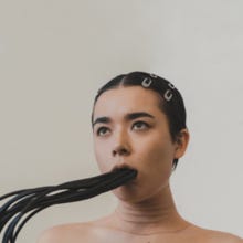 A picture of Margaret Sohn with cropped hair with black cables extending from her mouth A picture of Margaret Sohn with cropped hair with black cables extending from her mouth