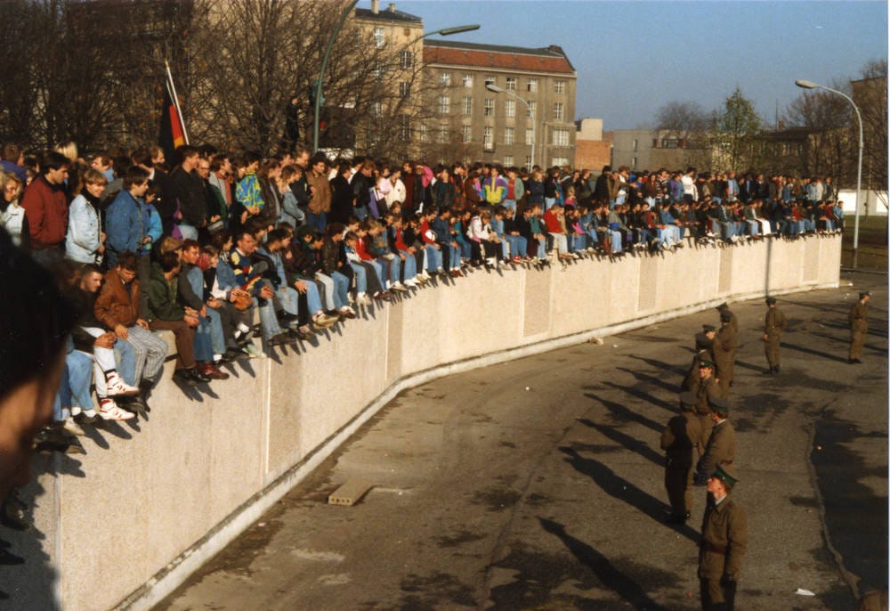 Grenzsoldaten überwachen die Menschenmassen auf der Grenzmauer am Brandenburger Tor Grenzsoldaten überwachen die Menschenmassen auf der Grenzmauer am Brandenburger Tor