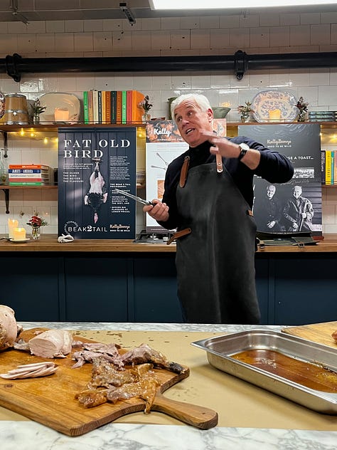 Paul Kelly of the Kelly Bronze company, standing behind a counter demonstrating carving technique.