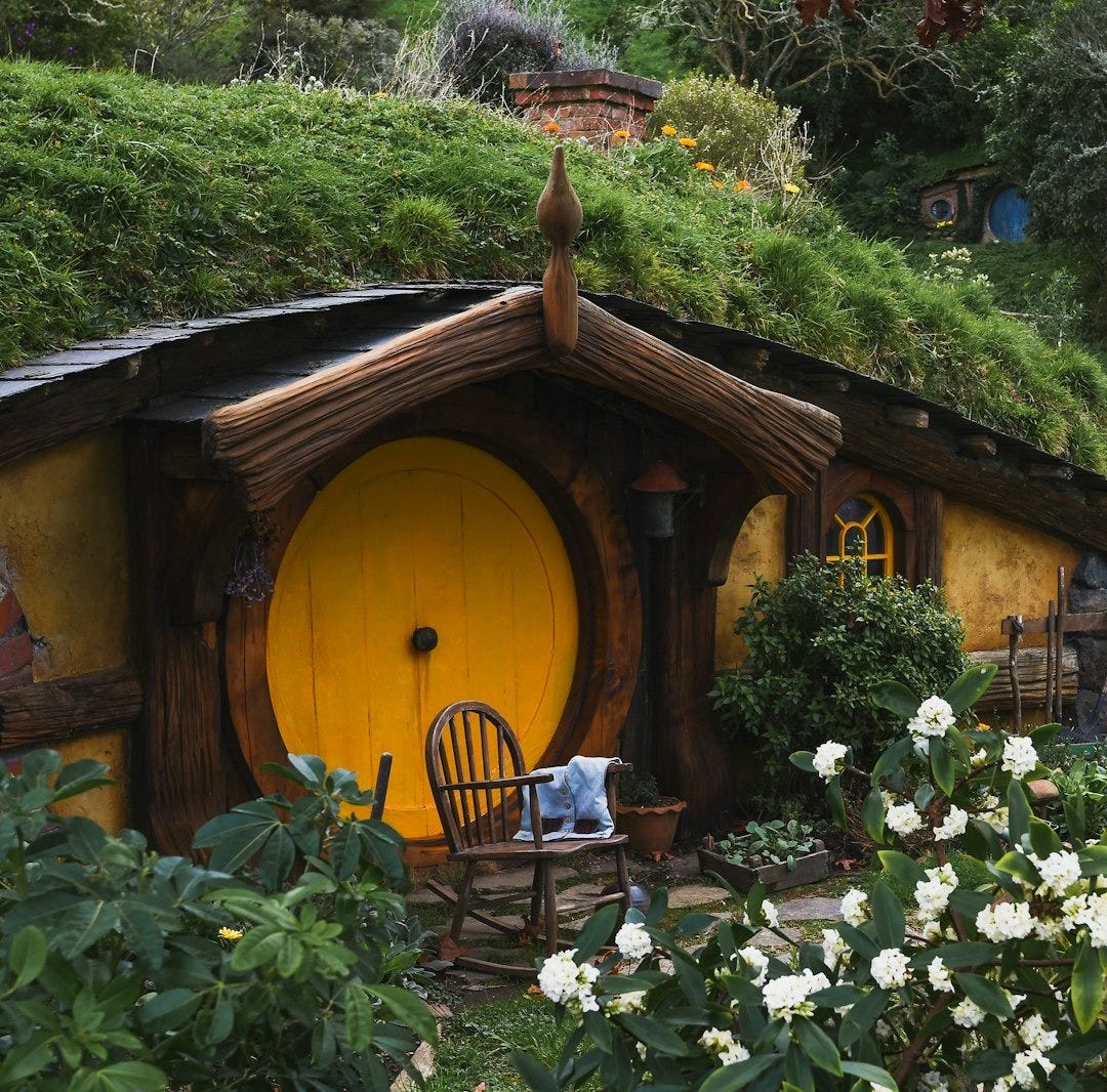 brown wooden house with white flowers and green plants brown wooden house with white flowers and green plants