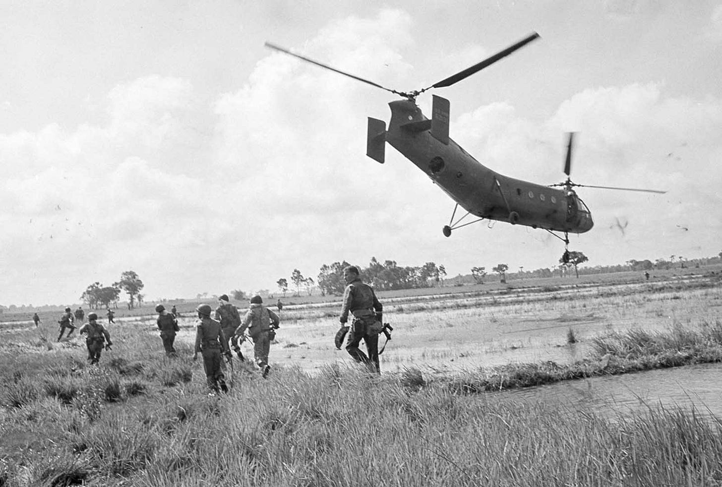 Vietnamese airborne rangers, supported by U.S. advisers and Special Forces, disembark from H-21 helicopters under sniper fire during a raid on a Viet Cong supply base northwest of Saigon, August 6, 1963.