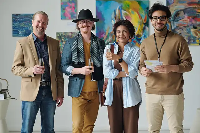 Artists and gallery visitors standing in front of colorful paintings with papers in hand