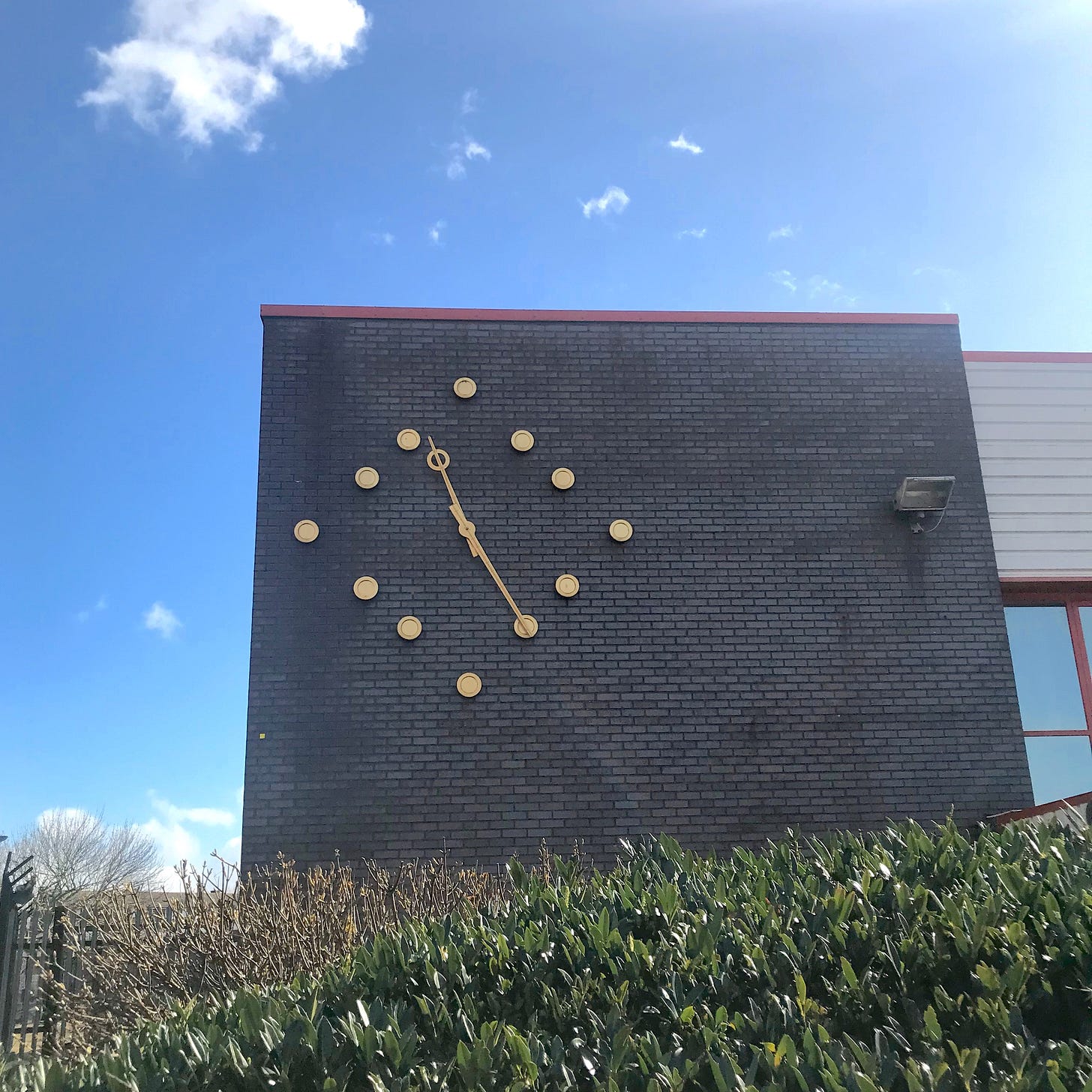 Photograph of an outdoor wall clock on a public building.