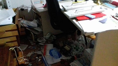 Banesa dhe biblioteka e Sadri Ramabajës pas demolimit (2016). Pamje nga brenda hapësirës së punës dhe shkallëve të banesës, të dokumentuara pas ngjarjes që ai e përshkruan si sinjal të ndjekjes së vazhdueshme. Fotot janë huazuar nga Sadri Ramabaja.