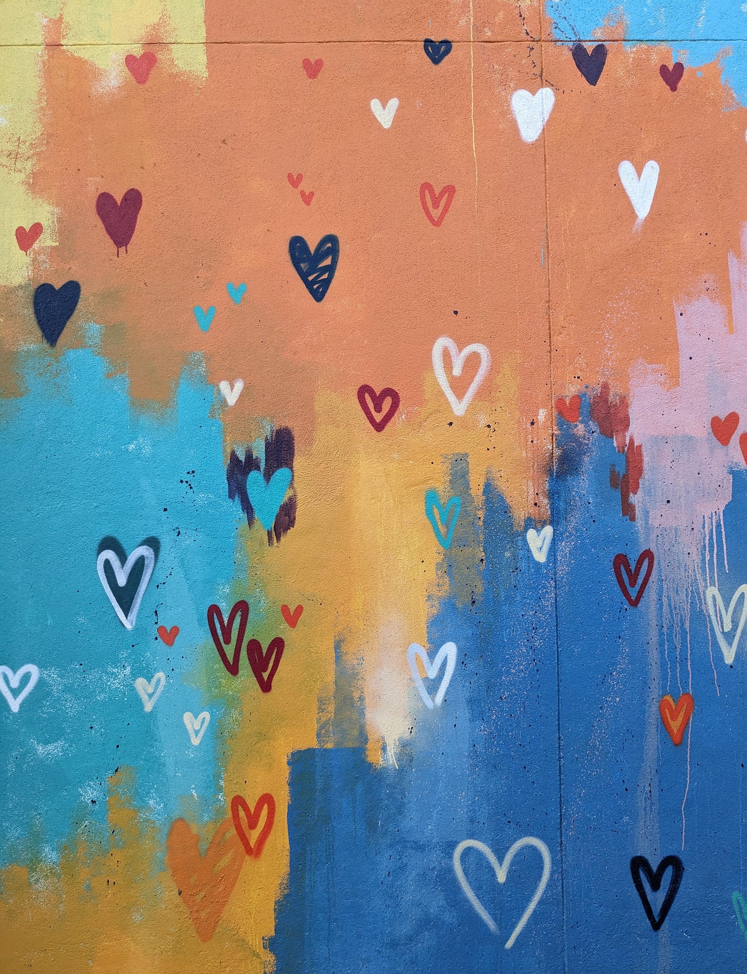 mural colorido com vários corações, também coloridos, desenhados.