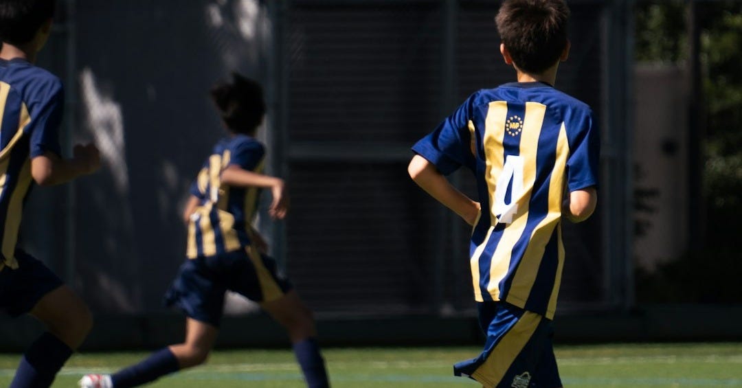 a group of young men playing a game of soccer a group of young men playing a game of soccer