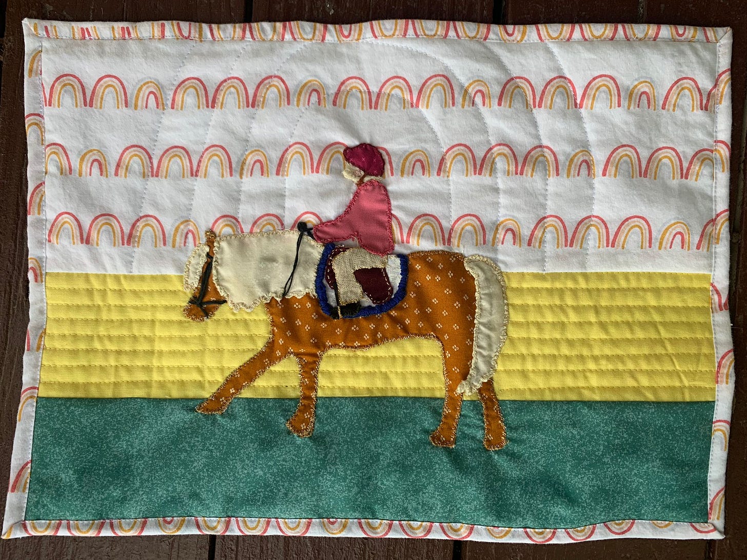 Image Description: Jo’s commissioned quilt—a girl riding a horse. 