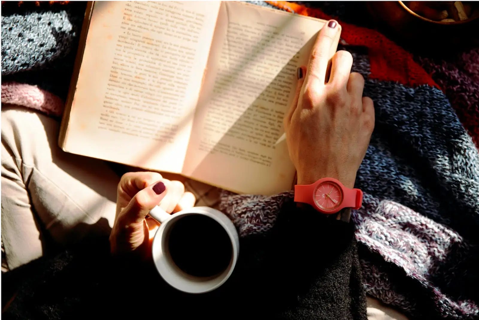 woman reading a book and drinking coffee and learning about the role of the family scapegoat