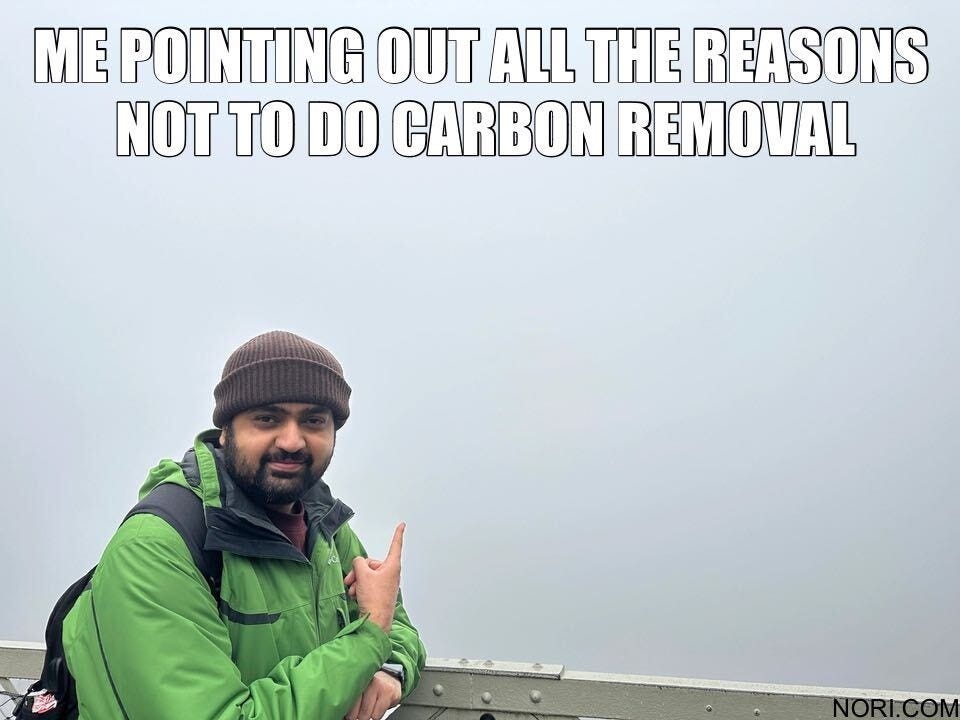 Text: "Me pointing out all the reasons not to do carbon removal." Below, a smiling man in a beanie and green jacket pointing at empty grey fog.