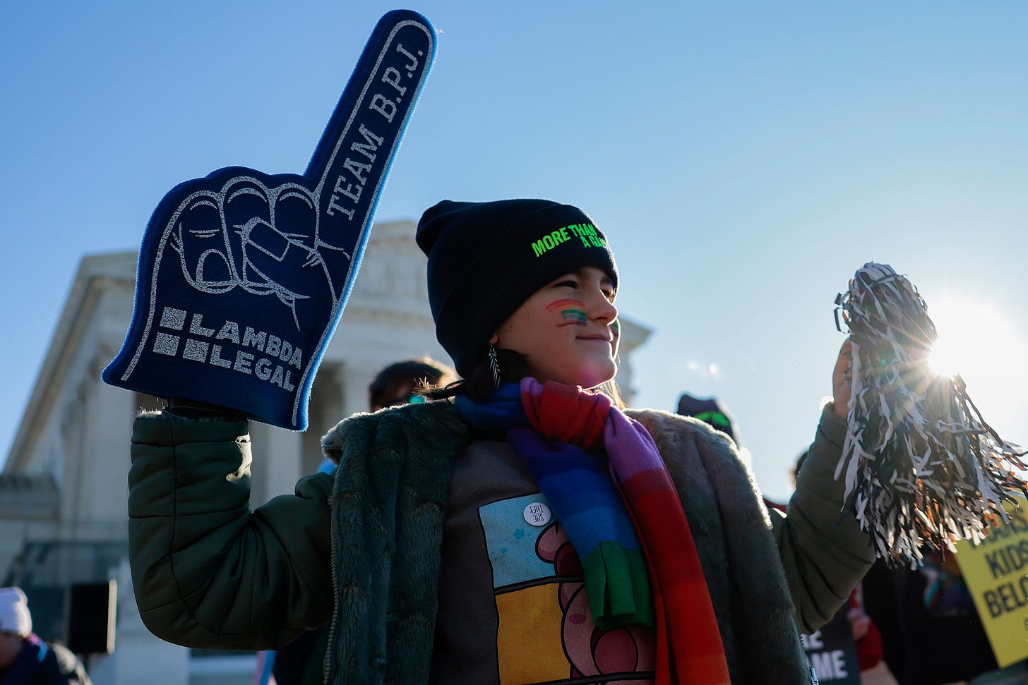 A supporter outside the Supreme Court holds a Team B.P.J. foam finger and a silver pom-pom. A supporter outside the Supreme Court holds a Team B.P.J. foam finger and a silver pom-pom.