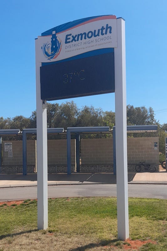 Photo of a sign outside Exmouth District High School. The sign features a current temperature reading of 37 degrees.