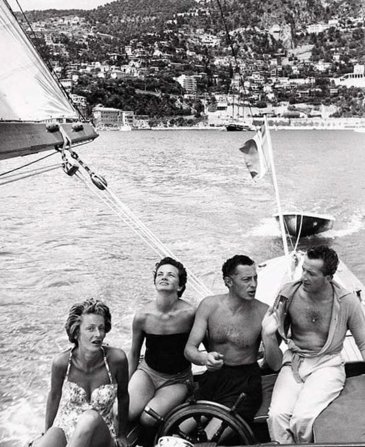 This may contain: black and white photograph of four people on a boat This may contain: black and white photograph of four people on a boat