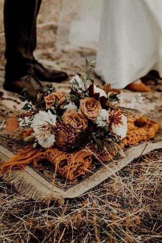 A bouquet of flowers on a rug

AI-generated content may be incorrect.