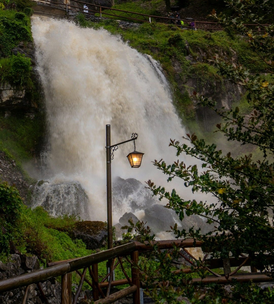 A waterfall with a lamp post in front of it