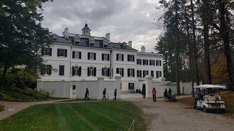 Edith Wharton's home in Lenox, Massachusetts--The Mount. The grand walled entrance in the back of the white stucco house in the Restoration style with green shutters. A long hallway with statues, the framed plaque outside the door to a room proclaiming it Henry James' guest room, and the pink dining room with an intimate table set for six, and a picture of the place set for Henry James. Each place has a picture of a favorite guest and their bio.