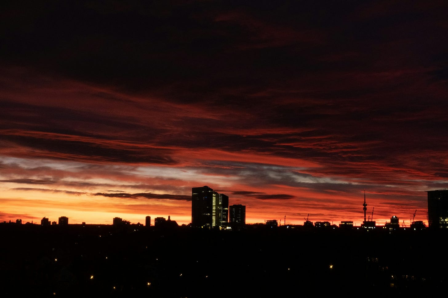 brooding sunset sky over city buildings and lights