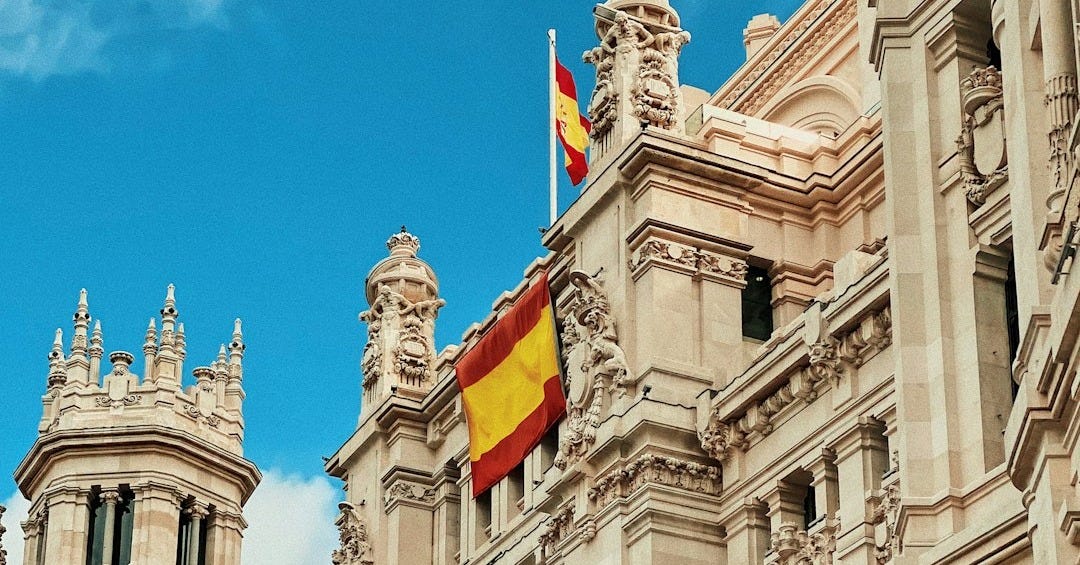 yellow and red flag hanging on white building