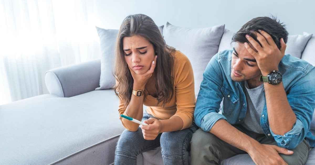Sad, stressed couple with pregnancy test
