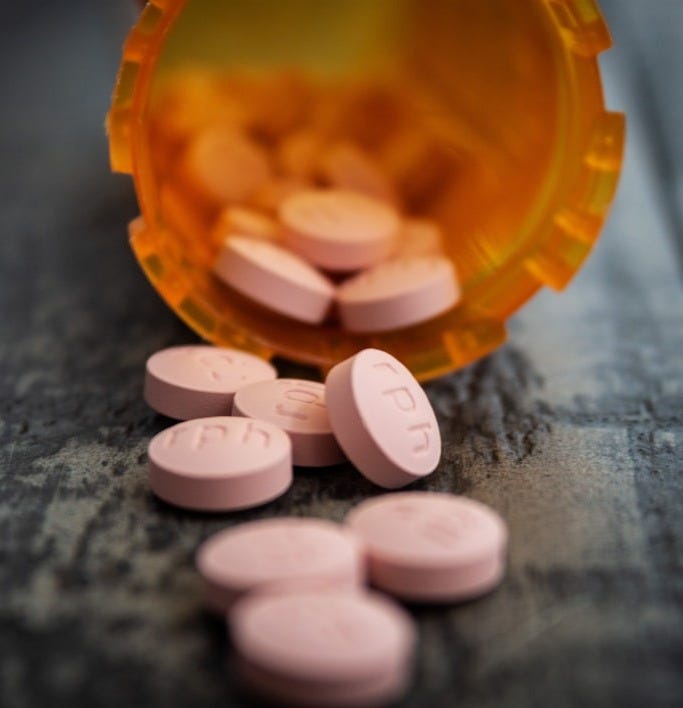 white medication pill on orange plastic container white medication pill on orange plastic container