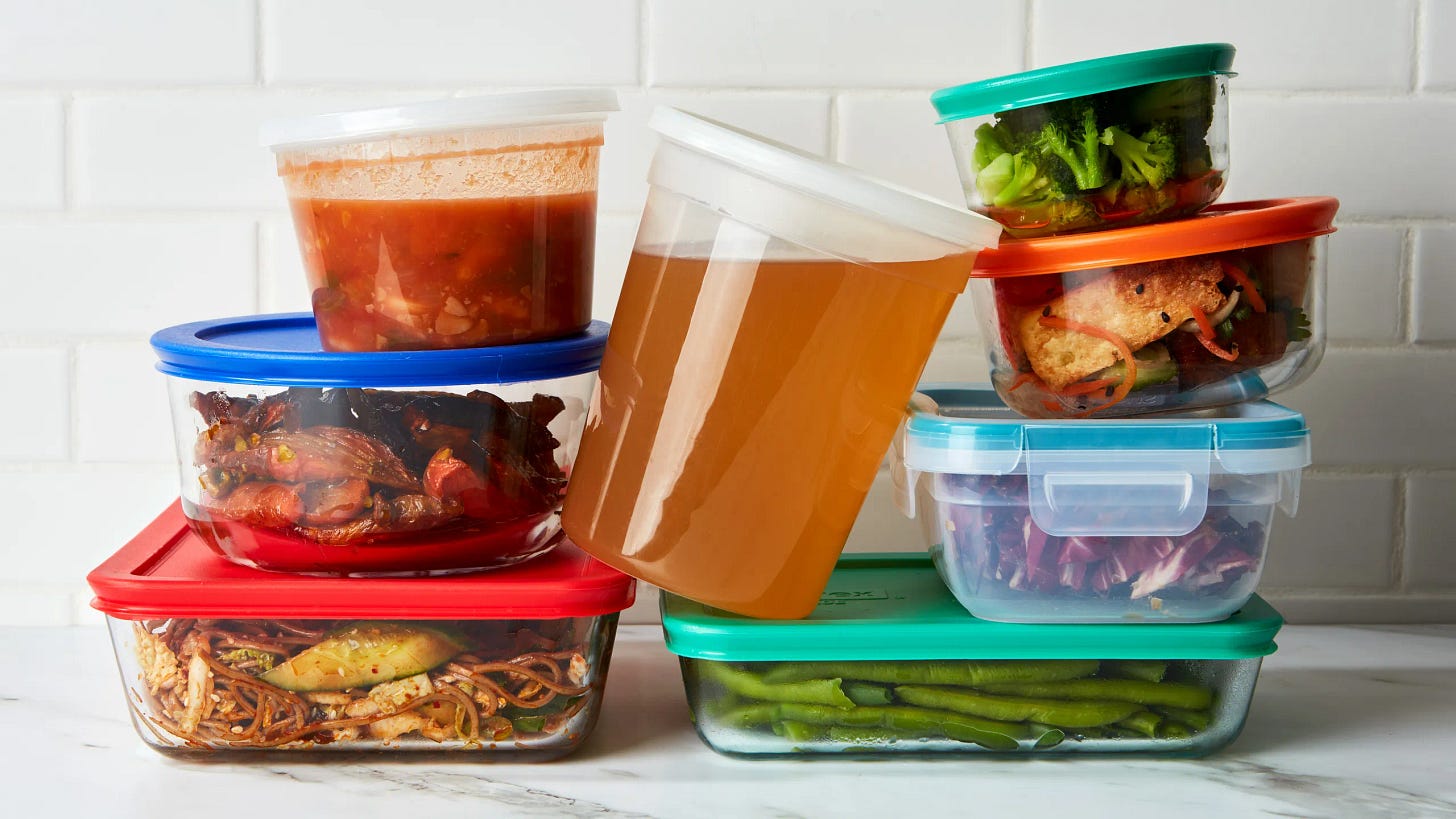 Food in colorful reusable containers on top of a white countertop