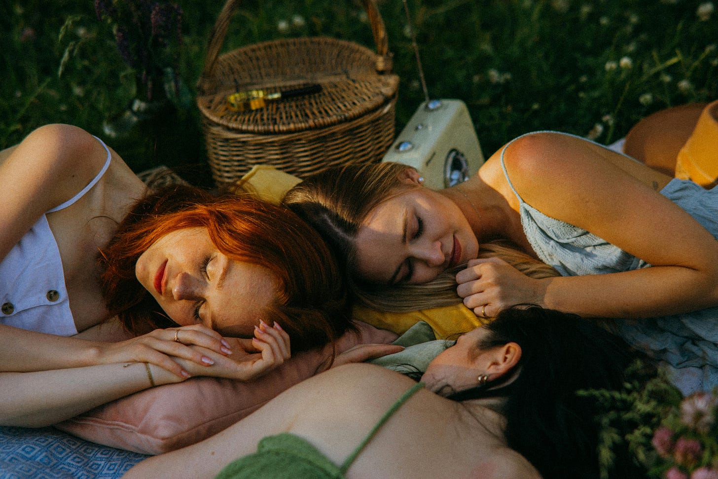 Drei Frauen liegen schlafend auf einer Picknickdecke. Drei Frauen liegen schlafend auf einer Picknickdecke.